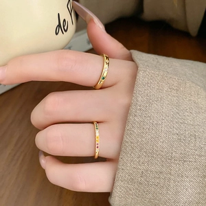Detail of vintage gold rings with iris rhombus patterns and colorful zircons on fingers