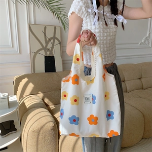 Dettaglio della borsa tote in tela floreale con patch LOVE e stampa di fiori