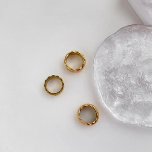 Detailansicht von drei goldenen Vintage-Ringen mit geflochtenem Design und Wellenrand