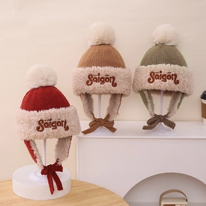 Detalle de gorros de punto de invierno cálidos con forro de piel sintética y pompones suaves