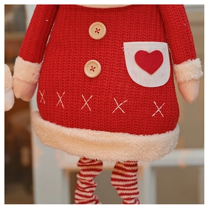 Detail of red knit Christmas doll with fuzzy white trim and wooden button accents