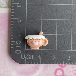 Macro shot of a miniature orange coffee cup resin craft accessory showing 1cm size scale