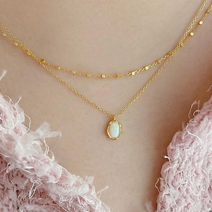 Double layered gold necklace with opal pendant on delicate chains worn by model