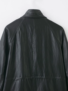 Detailed back view of vintage black faux leather jacket showing shoulder seams and texture