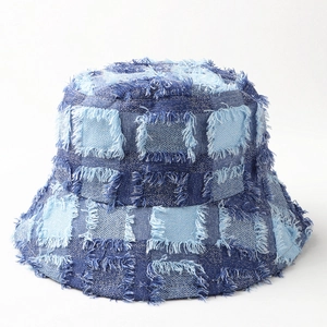 Detail of vintage denim patchwork bucket hat featuring frayed edges and street style design