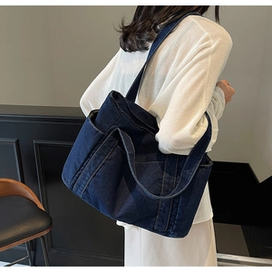 Detail shot of a dark blue denim tote bag showing its thick texture and large capacity