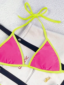 Detail of neon pink bikini top with contrasting yellow piping and adjustable straps