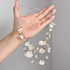 Détails de collier multicouche avec fragments de nacre et perles en cristal scintillantes