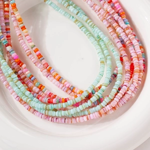 Collana multistrato di perline colorate in conchiglia naturale in una ciotola bianca
