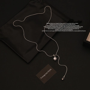 Macro detail of silver snake chain lariat necklace with square cubic zirconia pendant