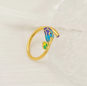 Macro shot of gold adjustable ring featuring colorful enamel floral leaf detailing