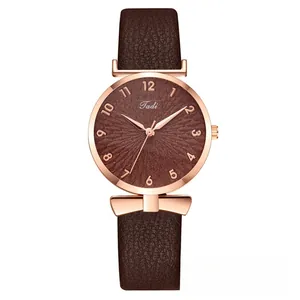 Detail of dark brown leather strap watch with rose gold case and bowknot-shaped lugs