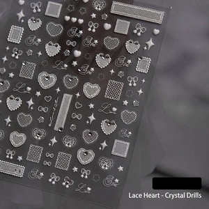 Macro shot of 3D embossed lace nail stickers with crystals heart and butterfly motifs