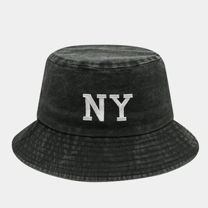 Detailed close-up of white NY letter embroidery on black washed cotton bucket hat