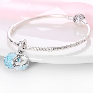 Macro shot of silver snake chain with blue enamel mermaid tail and moon pendant detail