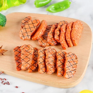 Realistic PVC roasted beef food model with grill marks on a wooden tray background