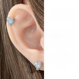 Detail of light blue heart-shaped zircon earrings with shell texture silver base