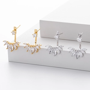 Macro shot of gold and silver fan-shaped marquise zircon earrings on geometric stairs
