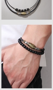 Detail view of woven wax rope necklace and bracelet set with retro metal pendant patterns