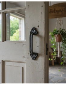 Detail eines Vintage-Schubladengriffs aus Gusseisen mit kleeblattförmiger Basis auf Holztür