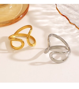 Dettaglio degli anelli aperti color oro e argento con design a linee curve vuote