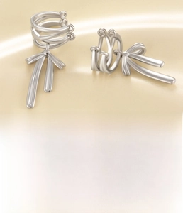 Macro shot of silver bow pendant ear cuff made of copper and sparkling cubic zirconia