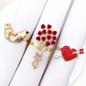 Three elegant rose and heart napkin rings with red rhinestones on white napkins