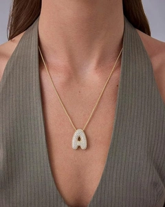 Close-up of 18K gold plated letter A pendant with sparkling zircon inlay on model neck