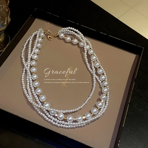 Elegant layered white pearl necklace with gold accents presented in a luxury gift box