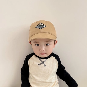 Close-up of khaki cotton baby sun hat with embroidered patch on a toddler model