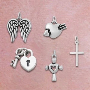 Macro detail of five silver stainless steel charms including angel wings and heart locks