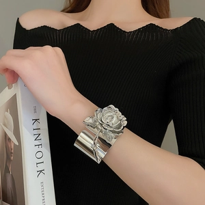 Close-up of a silver 3D rose cuff bracelet on a model wrist for a modern look