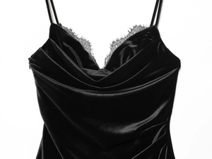 Detailansicht des eleganten Wimpernspitzenbesatzes am schwarzen Samtkleid-Ausschnitt