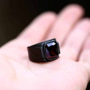 Macro shot of men's vintage stainless steel ring with a square-cut red gemstone inlay