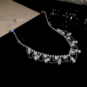 Close-up of tassel necklace with sparkling rhinestones and elegant pearls on black background