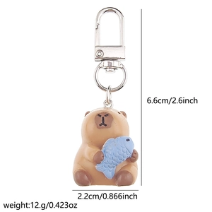 Detailed view of 3D Capybara keychain with blue fish including product dimensions
