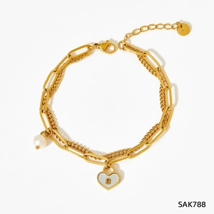 Détail du bracelet multicouche en acier doré avec pendentif cadenas cœur et perle
