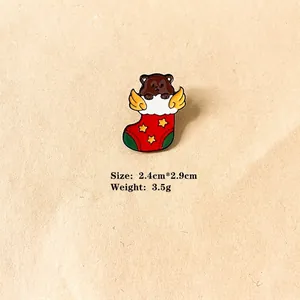 Detail of Christmas enamel pin featuring a cute brown bear in a holiday stocking