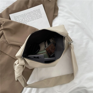 Japanese style minimalist beige canvas crossbody bag shown with earthy tone accessories