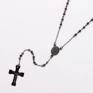 Close-up of matte black rosary necklace with cross pendant and beaded chain details
