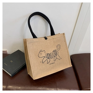 Detail of linen tote bag featuring black woven handles and minimalist animal print design