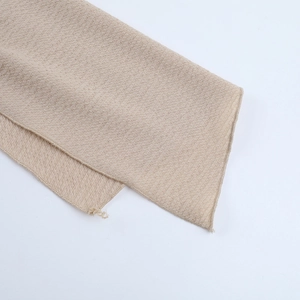 Detail of beige waffle weave fabric texture with close-up of intricate knit pattern