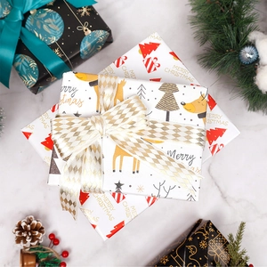 Christmas gift wrapping paper roll with reindeer trees and Merry Christmas text patterns