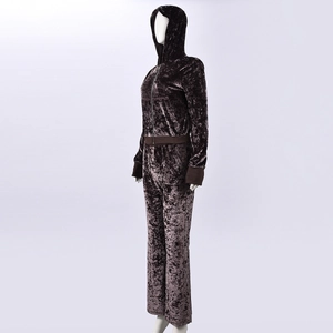 Detail of dark brown velvet tracksuit showing the soft embossed fabric texture on a mannequin