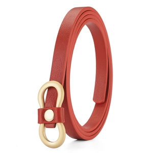 Detail of red leather belt featuring a unique gold figure-eight buckle on white background