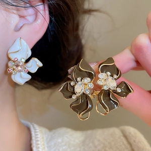 Detailed macro view of enamel flower earrings with sparkling crystals and gold plating