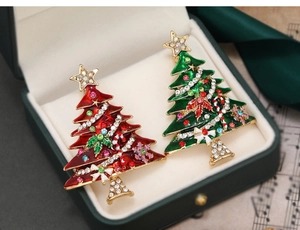 Detail of red and green rhinestone Christmas tree brooches in a premium jewelry gift box