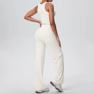 Dettaglio del set sportivo bianco con top incrociato e pantaloni yoga a gamba larga