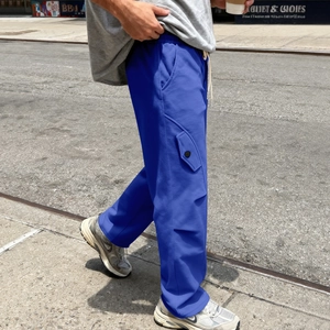 Dettaglio dei pantaloni sportivi blu hip-hop con elastico in vita, coulisse bianca e tasca laterale
