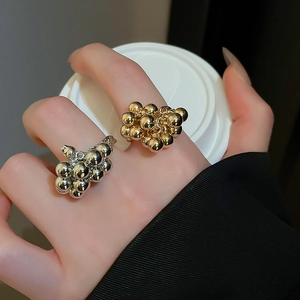 Macro shot of irregular clustered metal bead rings in gold and silver finish